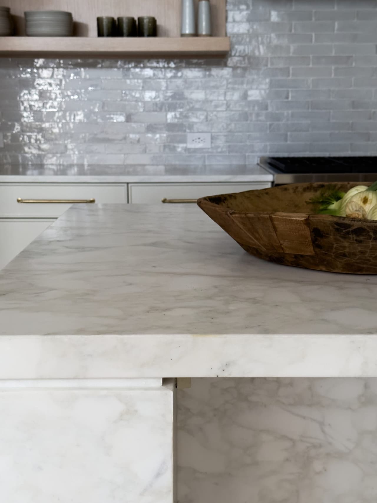 Mitred marble island edge above a glazed tile backsplash in a Westfield, NJ kitchen by Michael Robert Construction