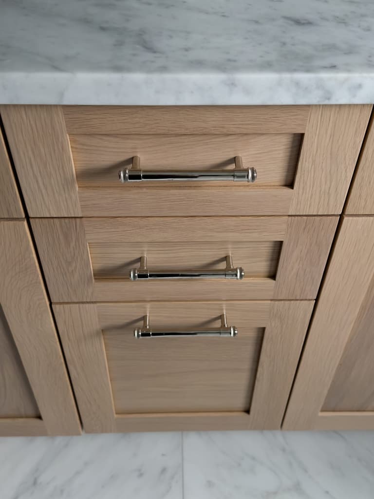 White oak shaker drawer fronts with polished nickel bin pulls under a marble top at a Westfield, NJ renovation and addition by Michael Robert Construction