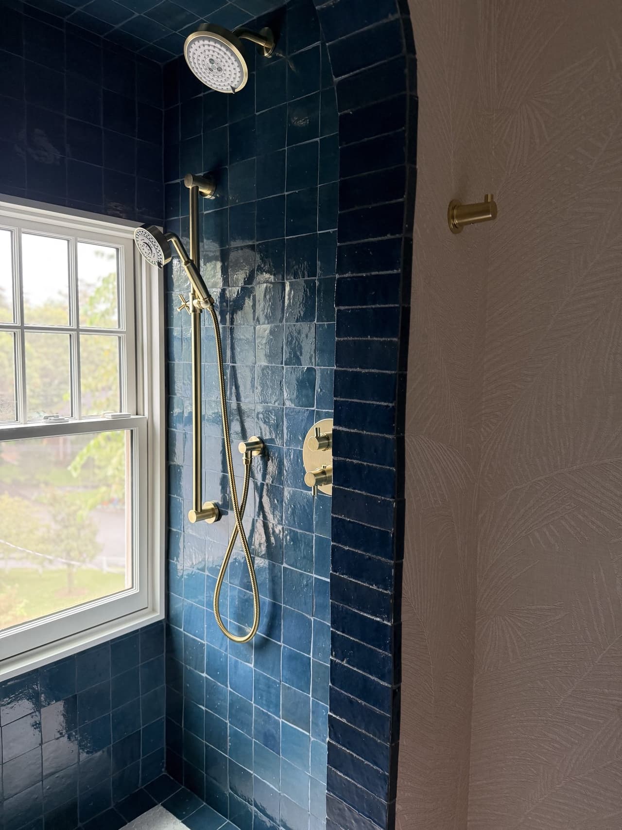 Arched blue zellige tile shower with brass fittings in a Short Hills, NJ bathroom by Michael Robert Construction