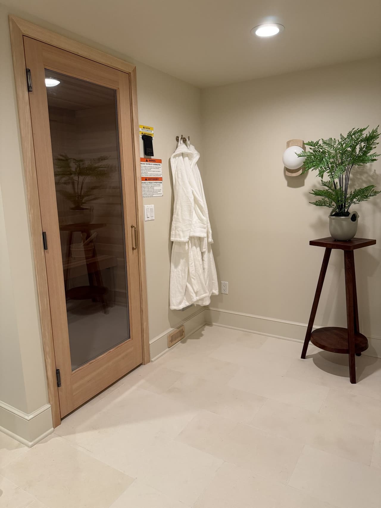 Cedar sauna behind a full-height glass door in a Short Hills, NJ basement spa by Michael Robert Construction
