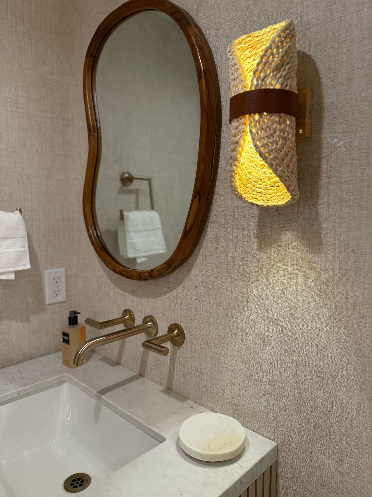Powder room with a brass wall-mount faucet and oval mirror in a Short Hills, NJ renovation by MRC