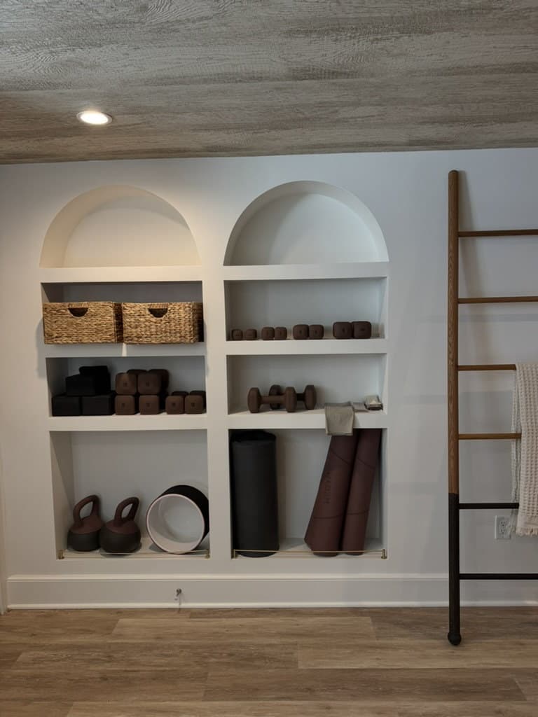 Arched built-in storage holding baskets, weights and rolled mats in a Short Hills, NJ yoga studio by MRC