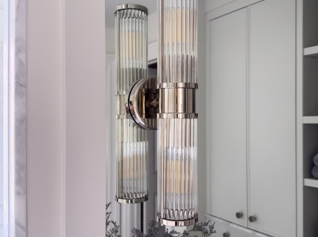 Fluted glass sconce in polished nickel beside the mirror of a luxury Summit, NJ primary bathroom renovation