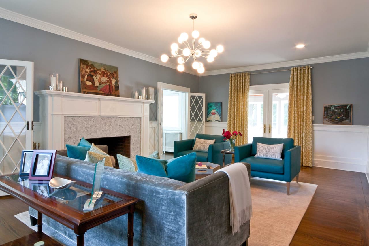 Living room seating around a tiled fireplace, with a sputnik chandelier and leaded-glass cabinet doors