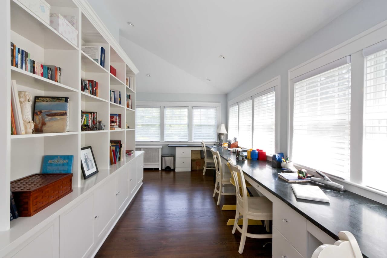 Long study in a Westfield, NJ renovation, with built-in bookshelves down one wall and a continuous desk under the windows opposite