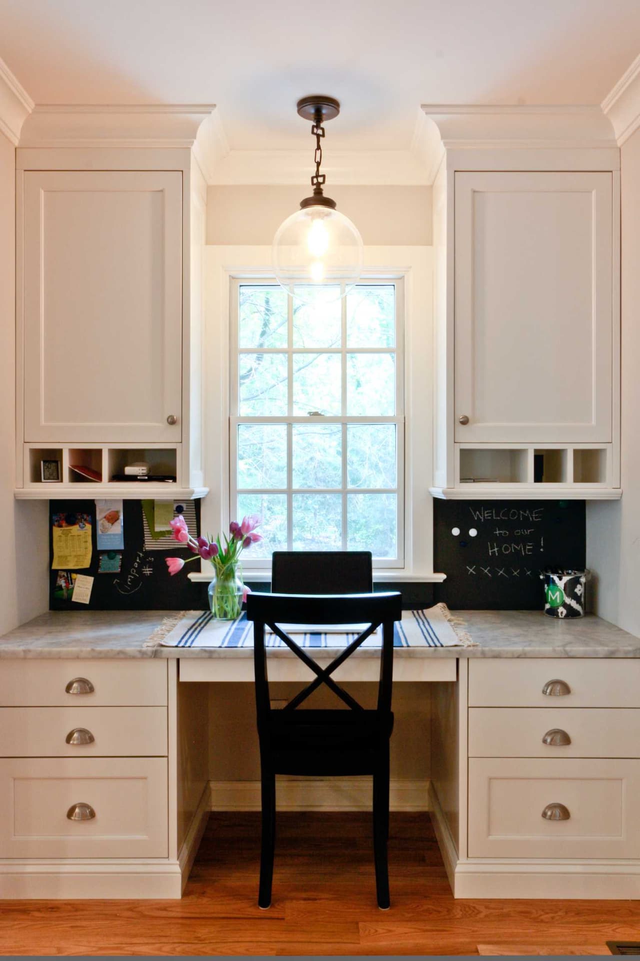 Built-in desk and cubbies under the window of a Westfield, NJ coastal colonial renovation, with chalkboard panels in the upper cabinet doors