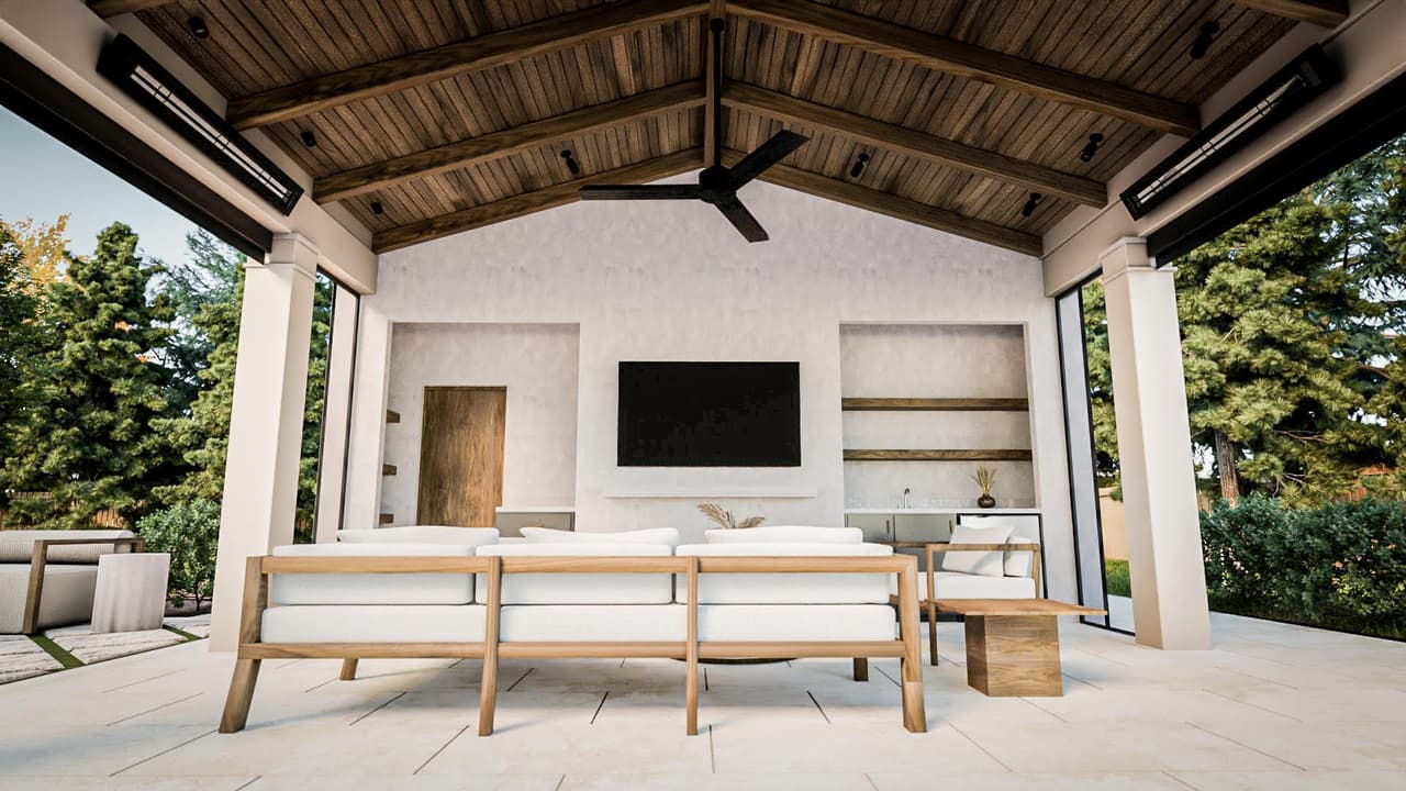 Covered outdoor room with a planked ceiling, a ceiling fan and a long table facing the garden