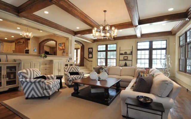 The family room of a Summit, NJ home before renovation, under a coffered ceiling with dark stained beams