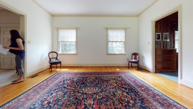 The dining room of a Westfield, NJ home before renovation and addition, emptied to the floorboards with a Persian rug and two chairs left in it