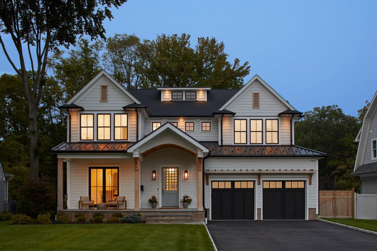 Custom new construction home at dusk with every window lit, in Westfield, NJ