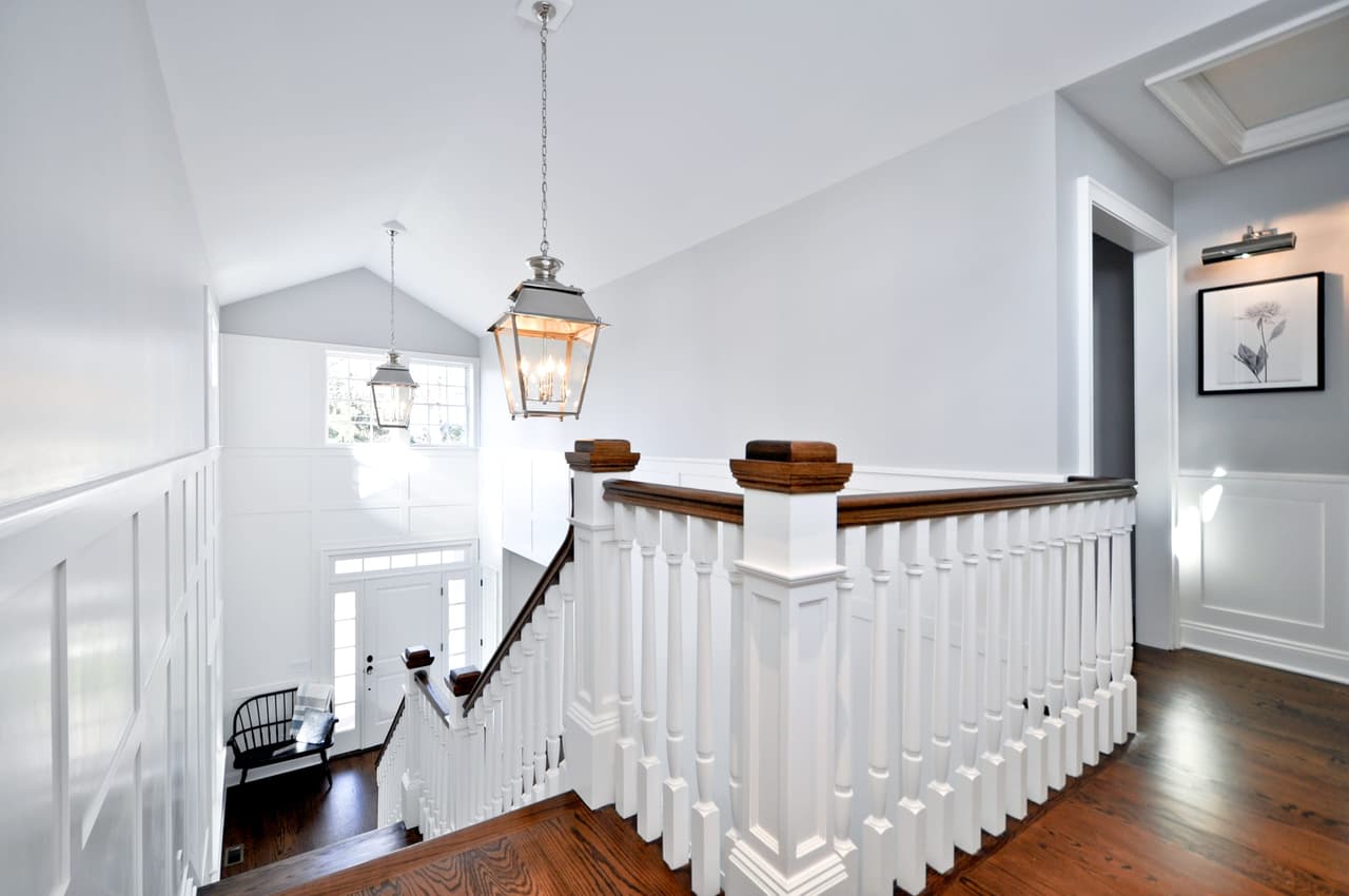 Upstairs landing with a white turned-baluster rail, a lantern pendant and a vaulted ceiling