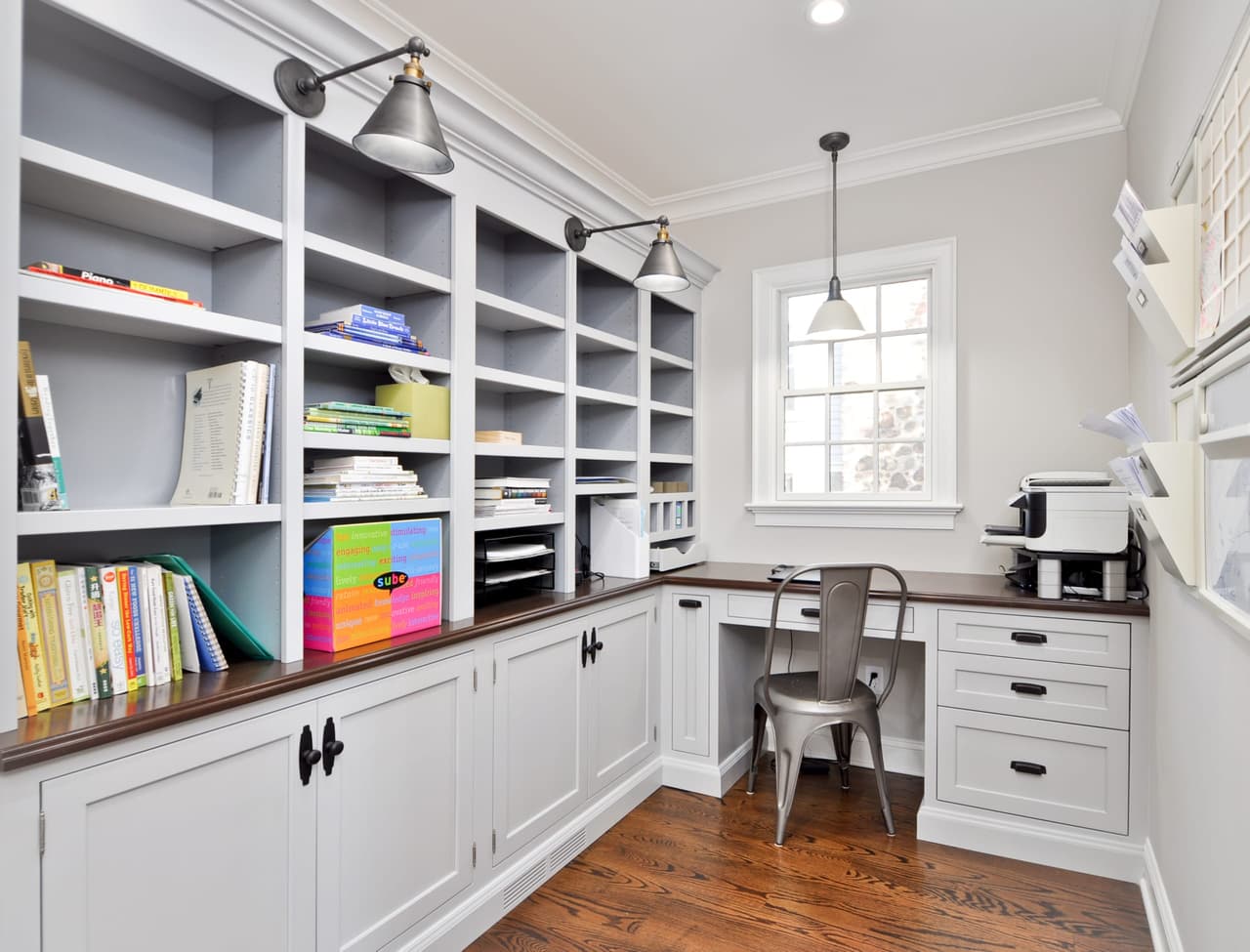 Built-in homework and craft wall with open cubby shelving, a wood counter and a desk under the window