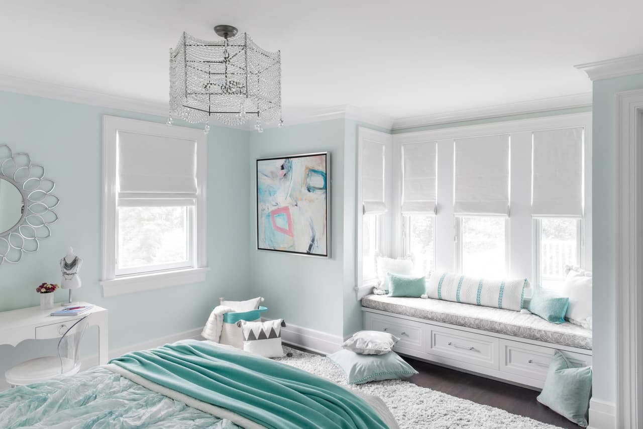 Bedroom in pale aqua with a window-seat bay, a lantern pendant and an upholstered bed