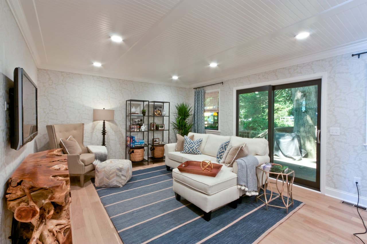 Living room with a live-edge console, a white sectional and steel shelving, open to the kitchen
