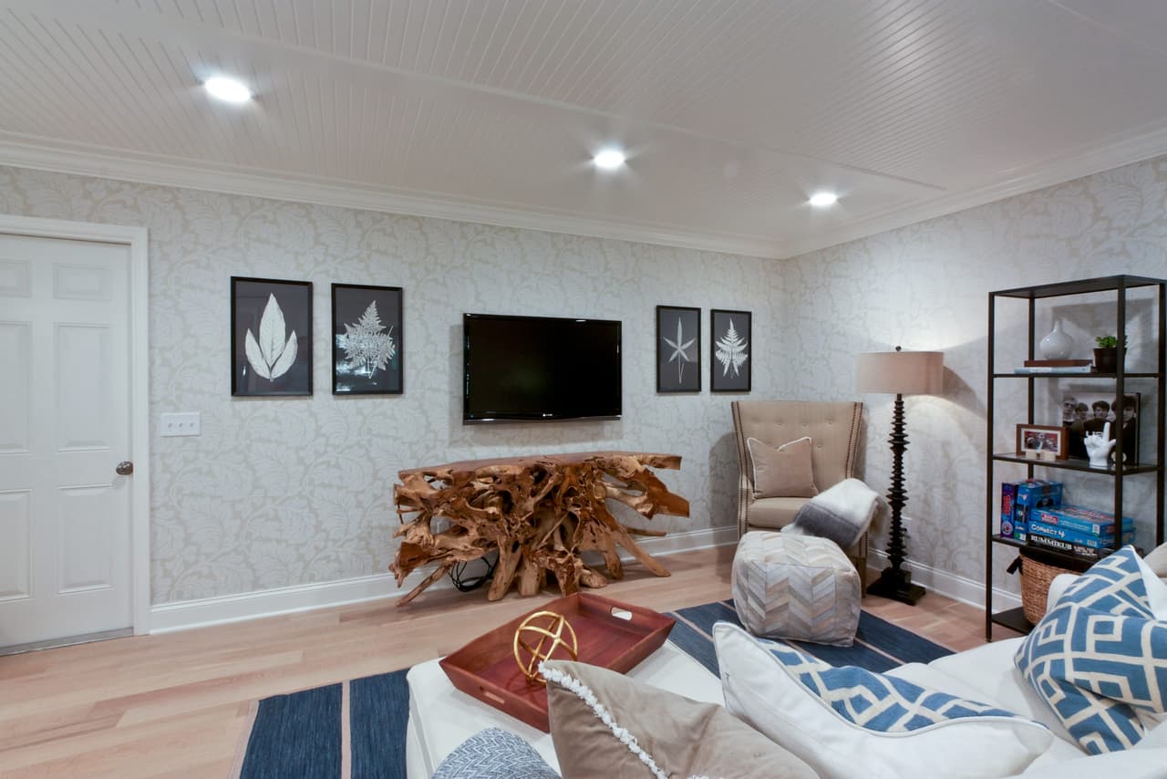 Living room with a wall-mounted television above a live-edge console, flanked by steel-framed shelving