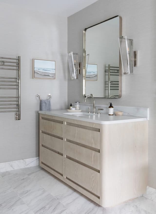 Bathroom in a Westfield, NJ home with a pale oak vanity, a pivoting mirror, a heated towel rail and a marble floor