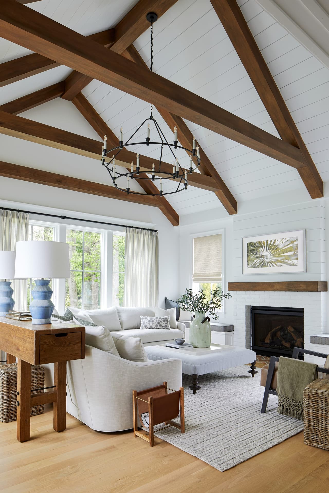 Family room under a vaulted shiplap ceiling with stained timber trusses, a lantern chandelier and a fireplace