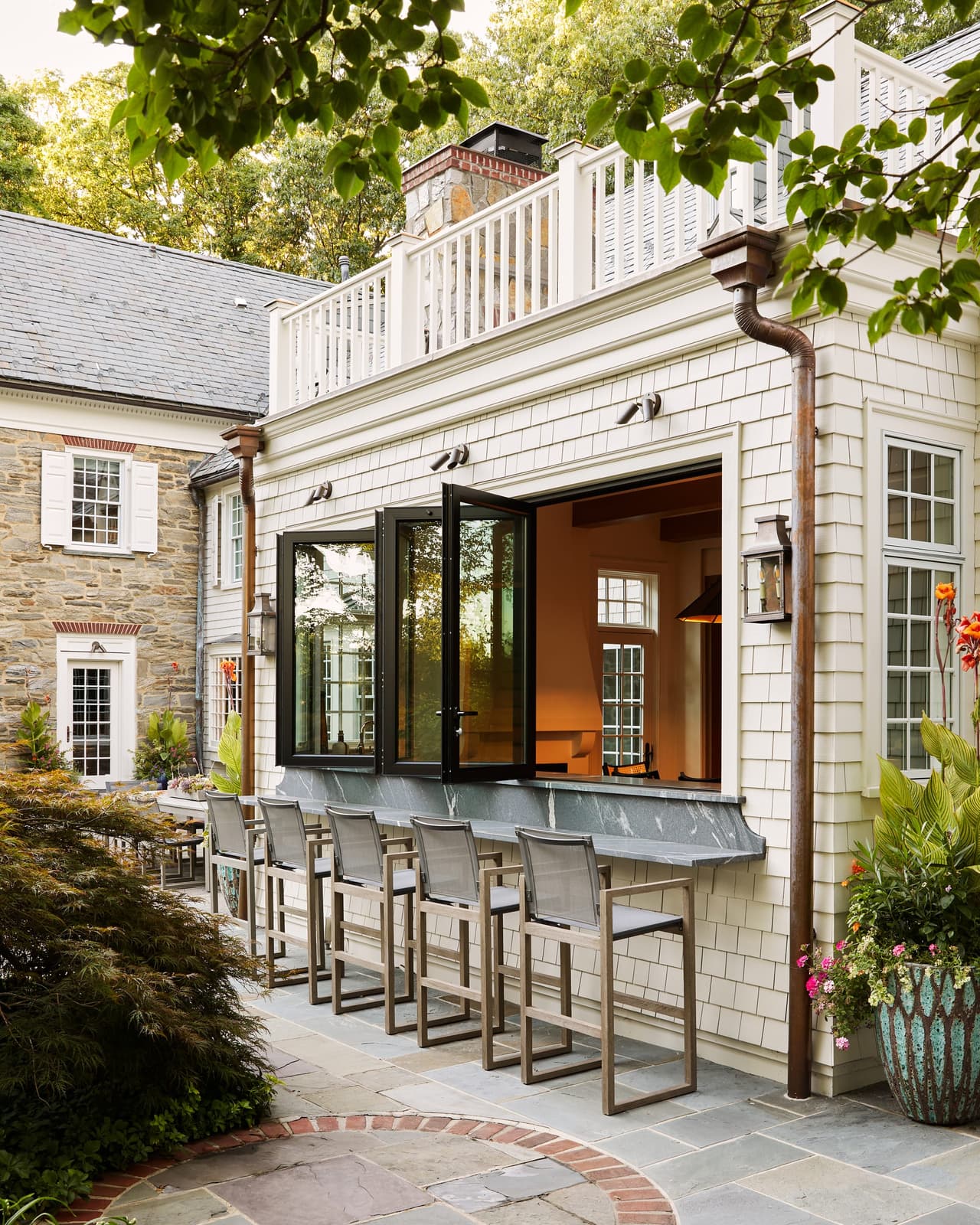 The same outdoor bar at a Westfield, NJ home renovation with its pass-through window folded open to the lit room inside