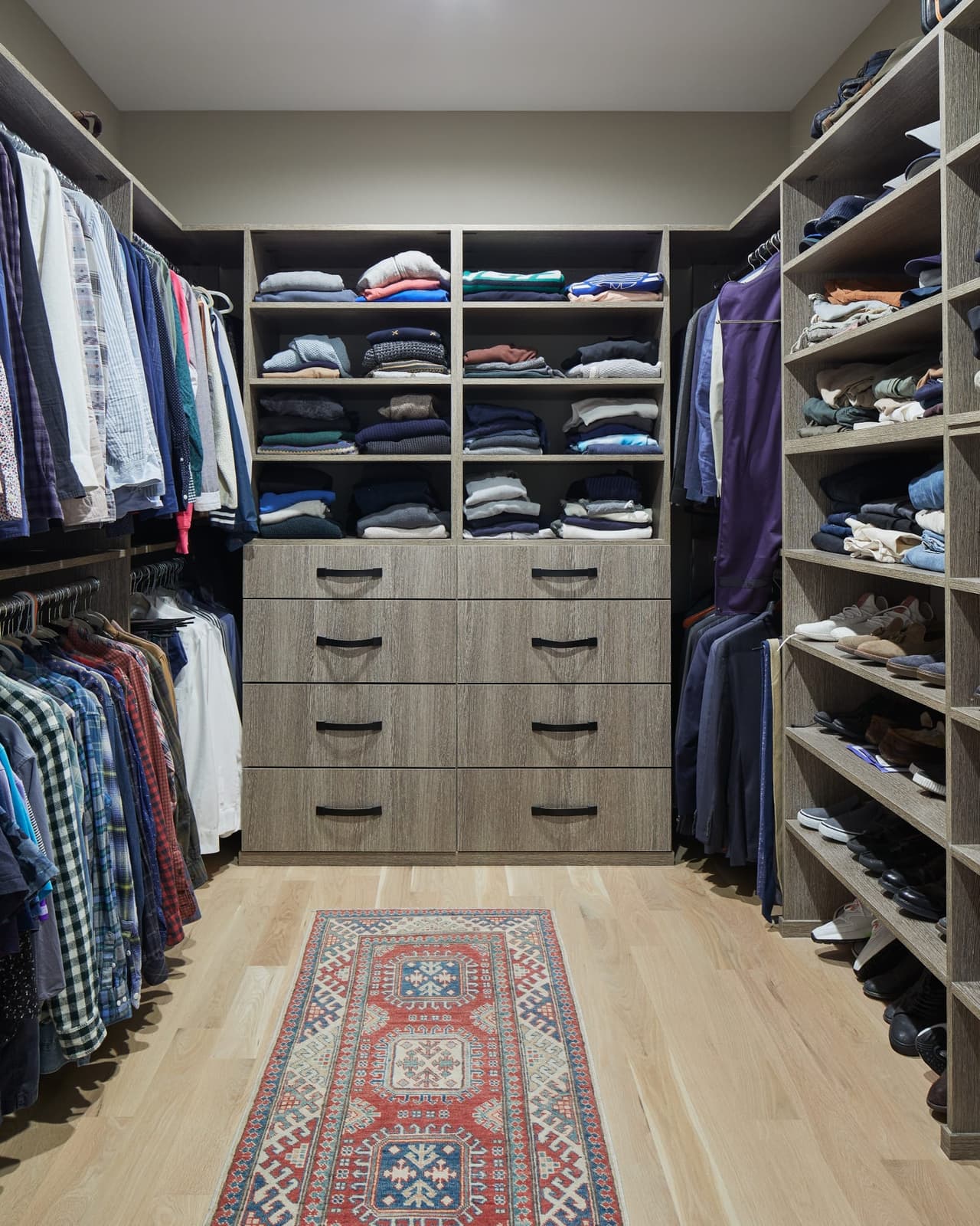 Fitted walk-in closet in a Westfield, NJ new-construction home, with hanging rails, open shelving to the ceiling, a bank of drawers and racked shoes