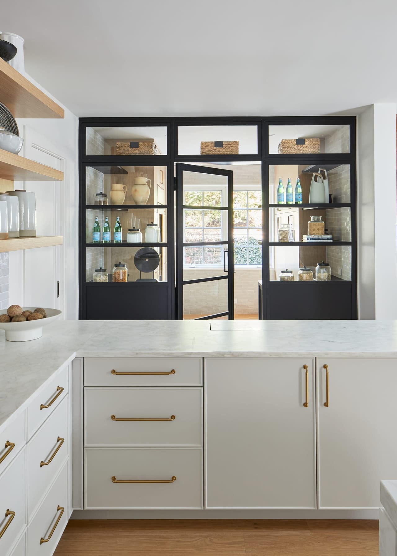 Glass-and-steel pantry cabinet above custom drawers with brass pulls in a Westfield, NJ kitchen renovation