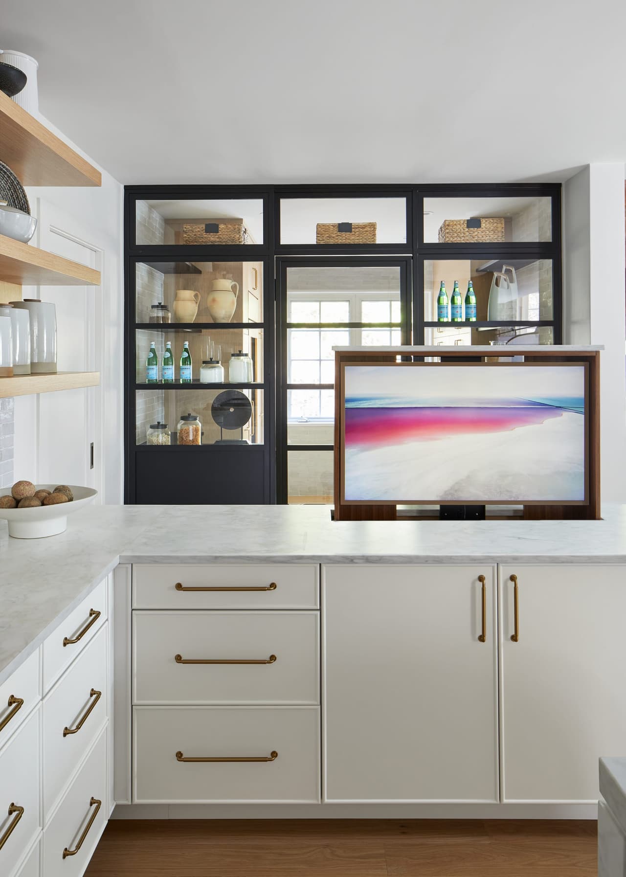 Television set into the end of a kitchen island below a black steel display cabinet in a Westfield, NJ kitchen renovation