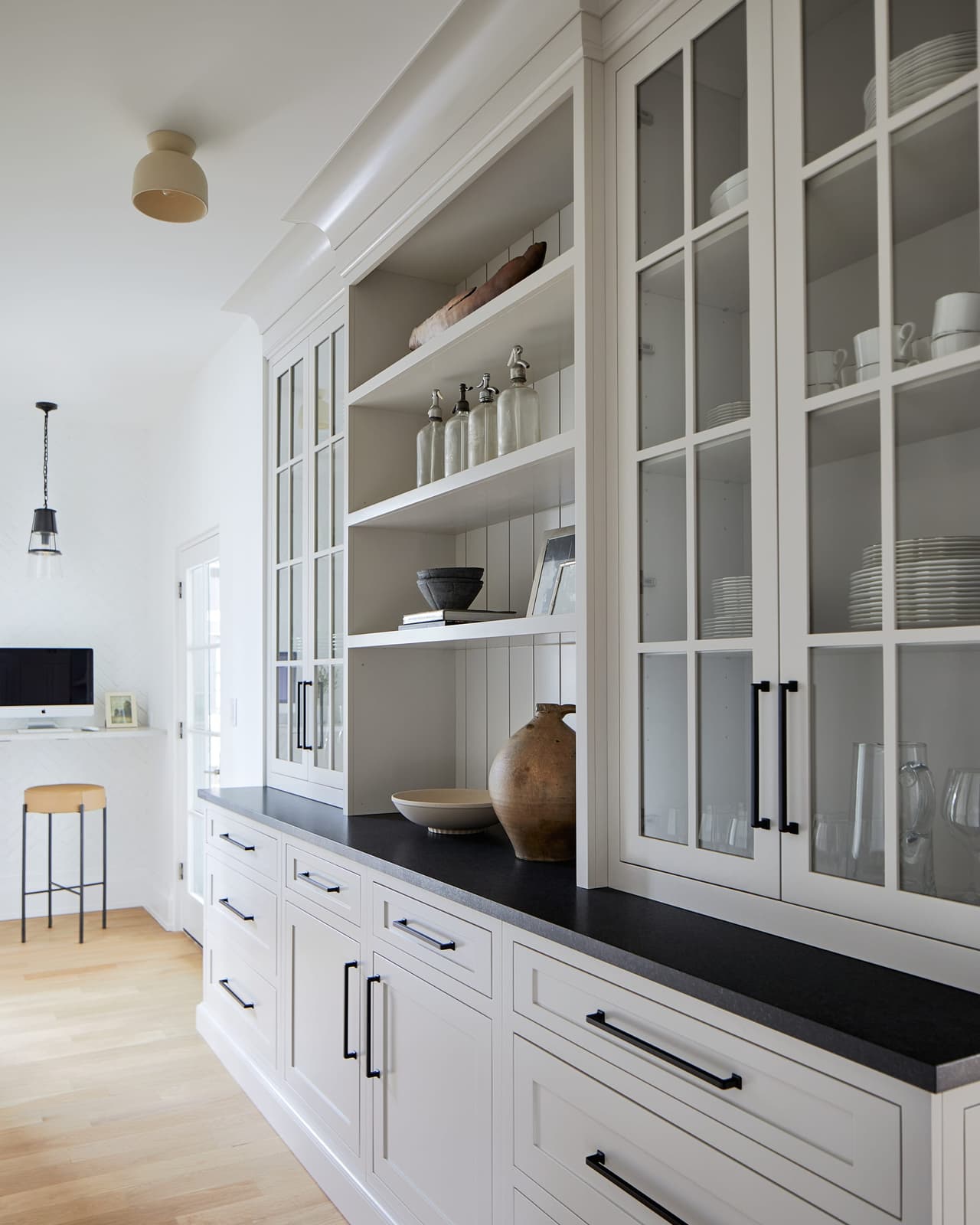 Butler's pantry in a Westfield, NJ addition and whole-home renovation, with glass-front upper cabinetry, open shelving and a soapstone counter