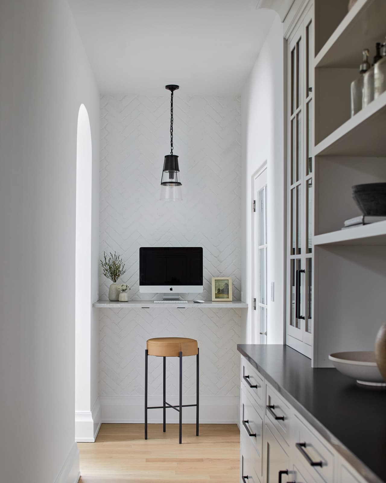 Butler's pantry with a built-in office station in a Westfield, NJ addition and whole-home renovation, under a herringbone-tiled wall and a glass pendant