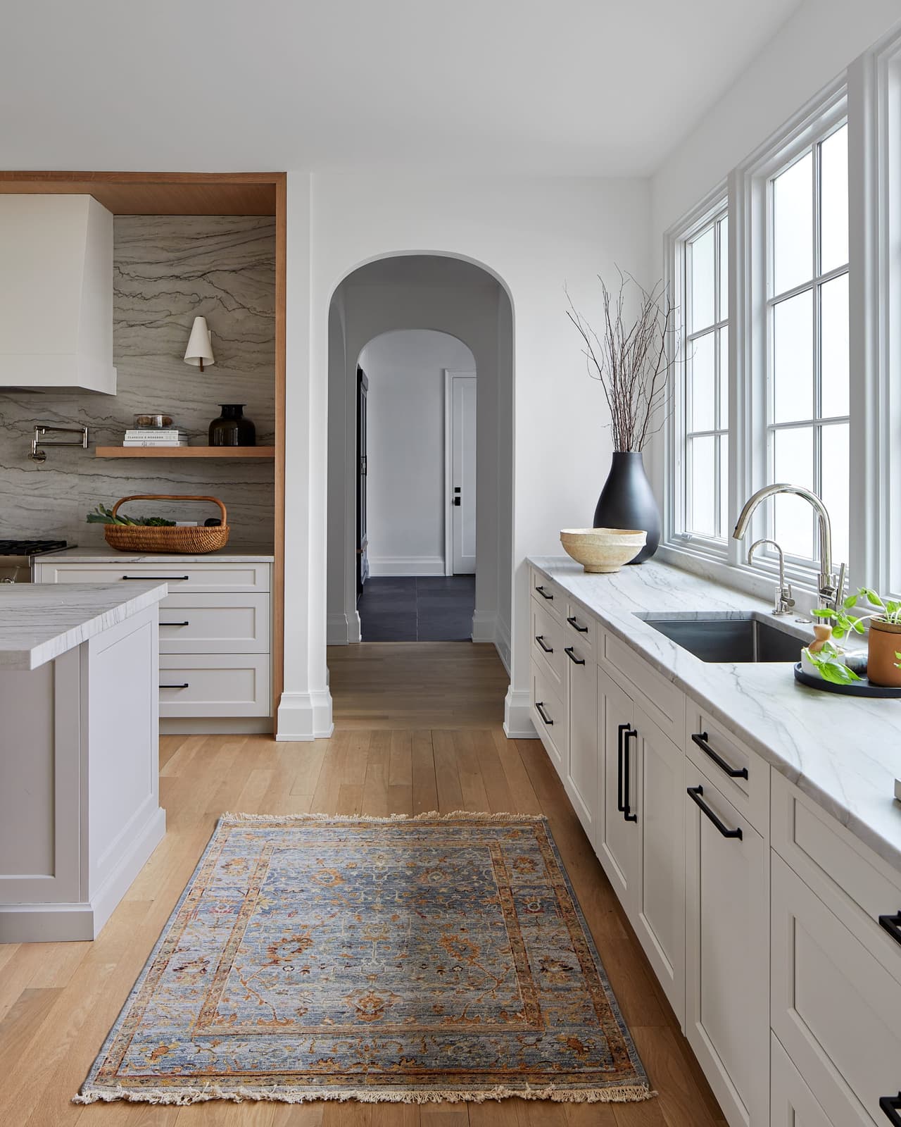Arched openings at either end of a galley run in a Westfield, NJ home addition and renovation, with a runner between the counters