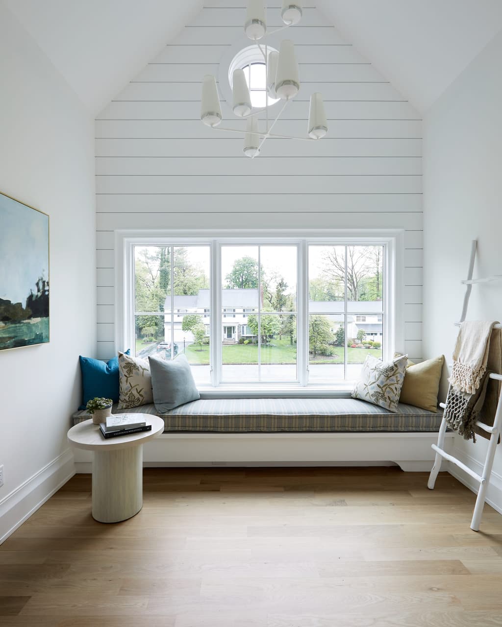 Reading nook with a built-in window seat under a gabled shiplap ceiling in a Westfield, NJ new-construction home