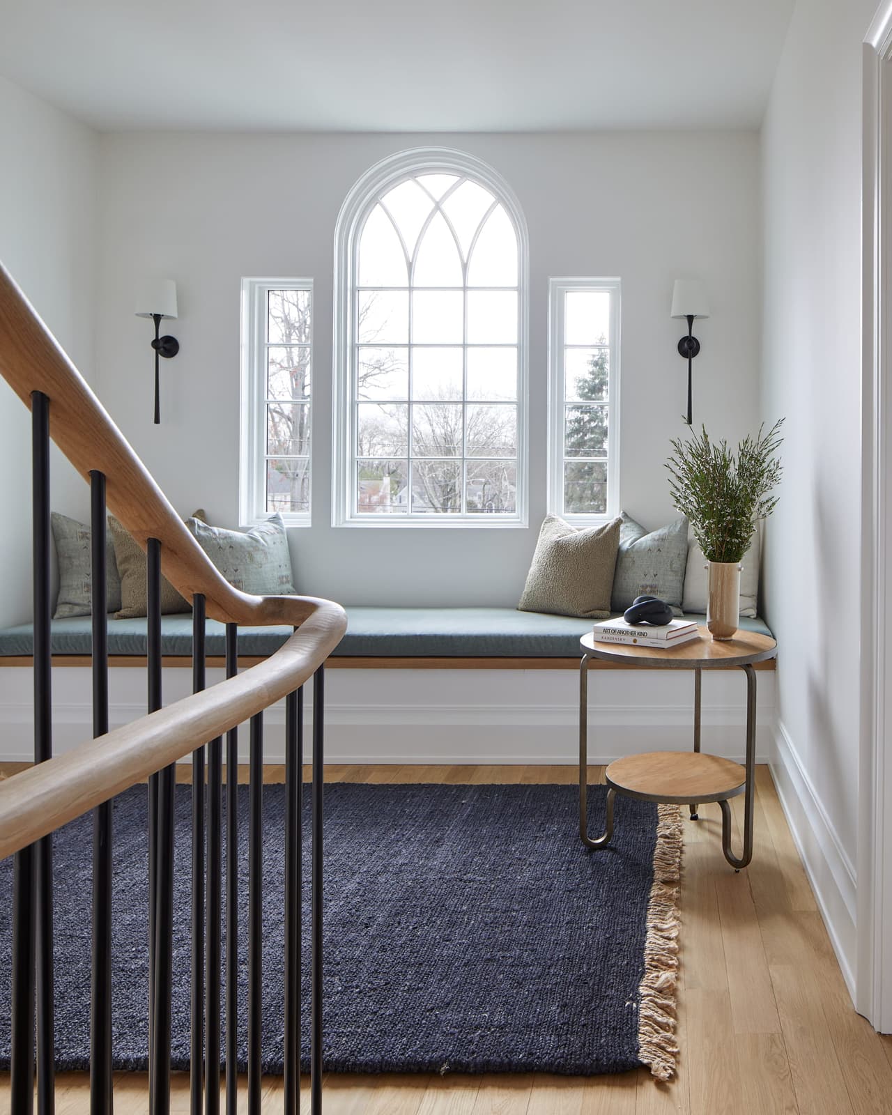 Stair landing of a Westfield, NJ addition and renovation, with a round-headed window over a window seat between two sconces