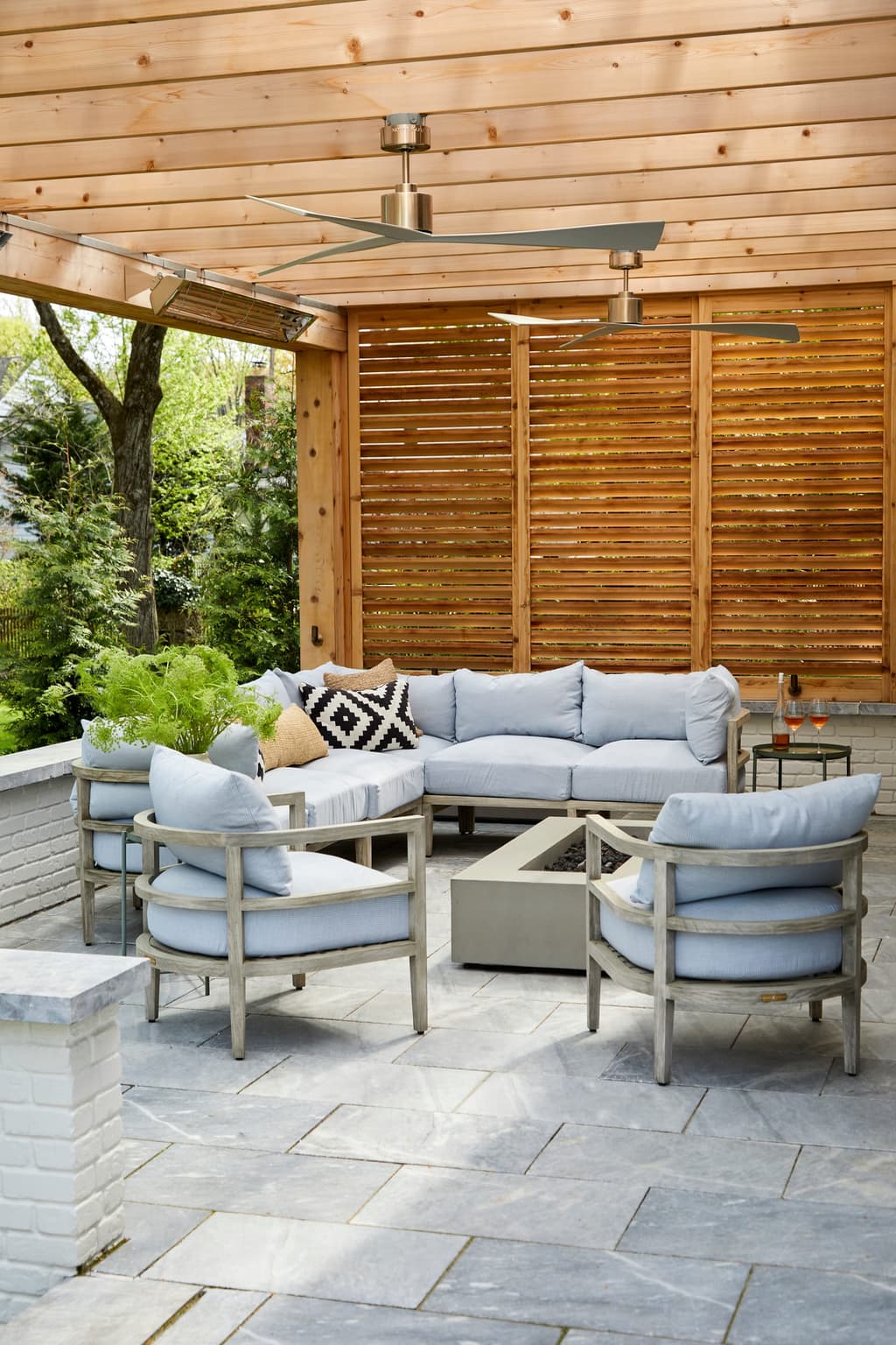 Covered patio at a Westfield, NJ new-construction home, with a cedar-lined pergola ceiling, a louvered cedar screen and a sectional on bluestone