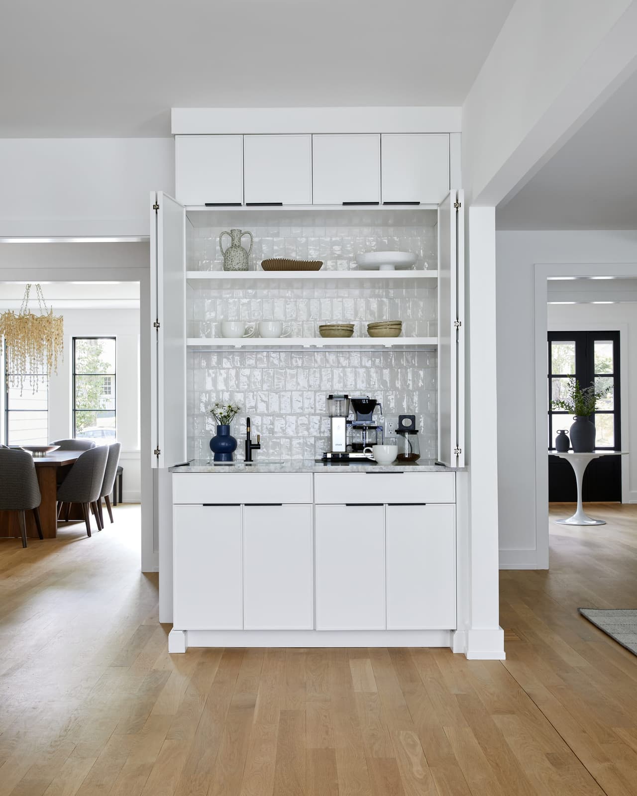 Coffee bar with white cabinetry, a white tiled back and glass-front uppers in a Westfield, NJ kitchen renovation