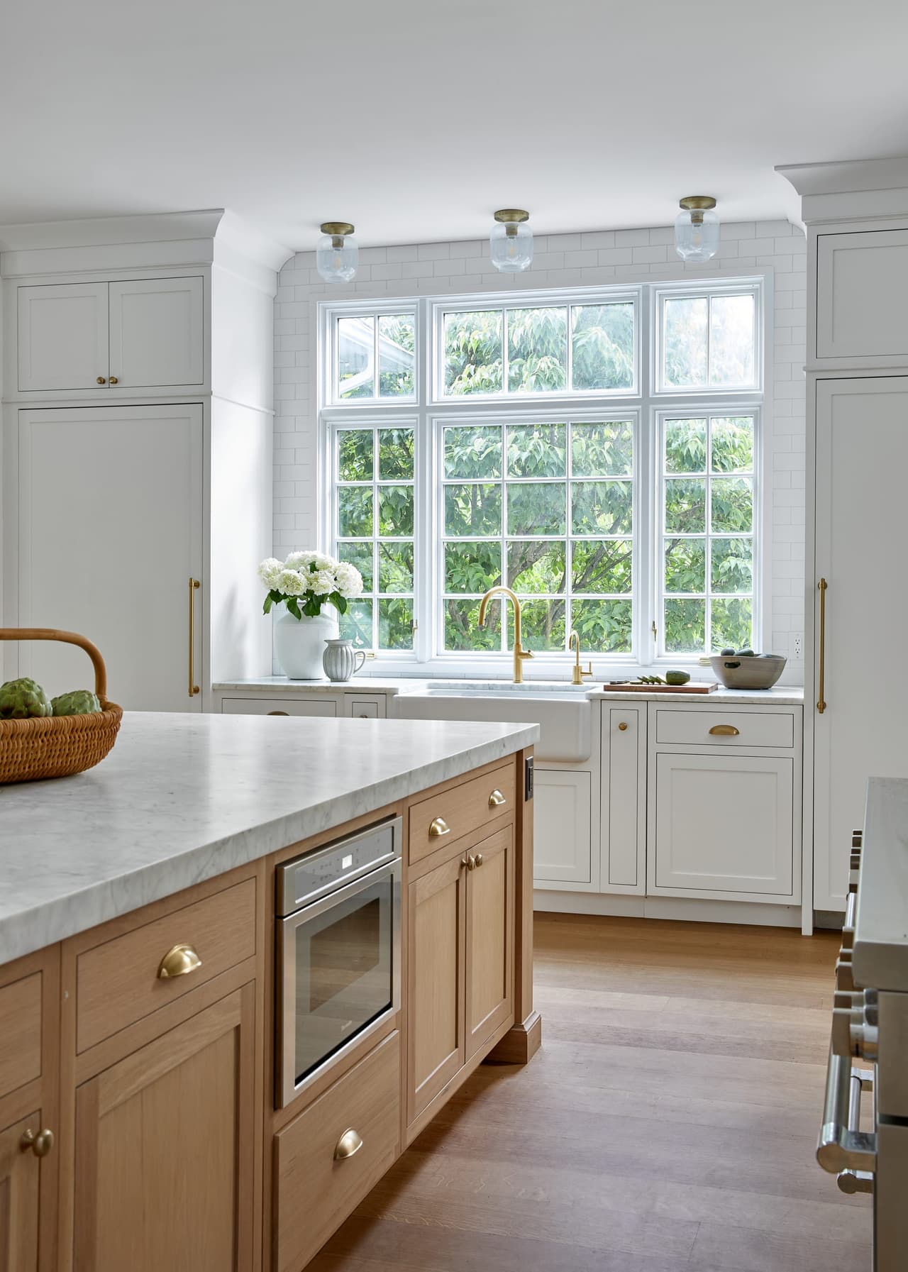 White kitchen with natural island and brass hardware