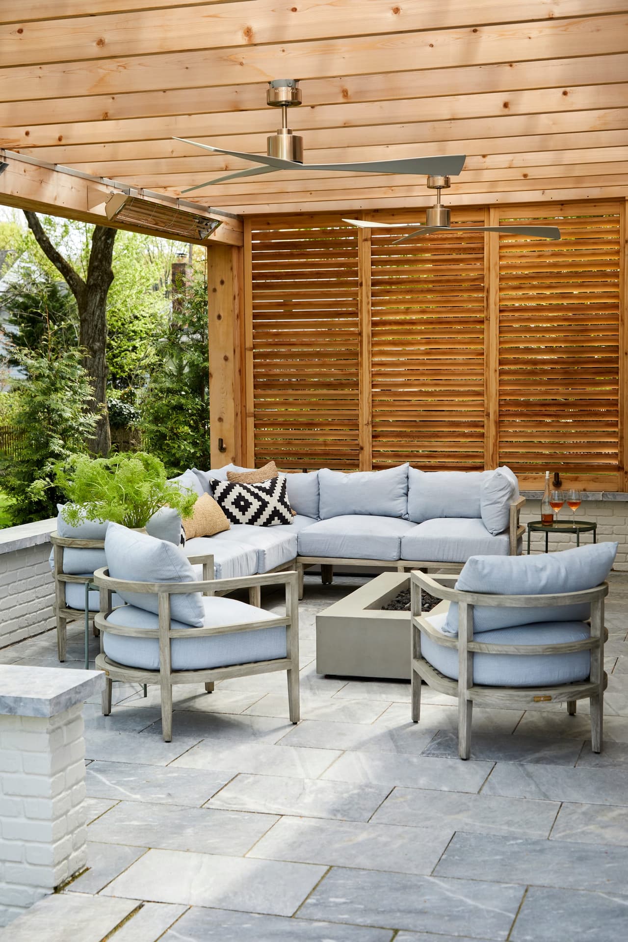 Covered patio with a cedar ceiling, a slatted privacy screen and cushioned seating