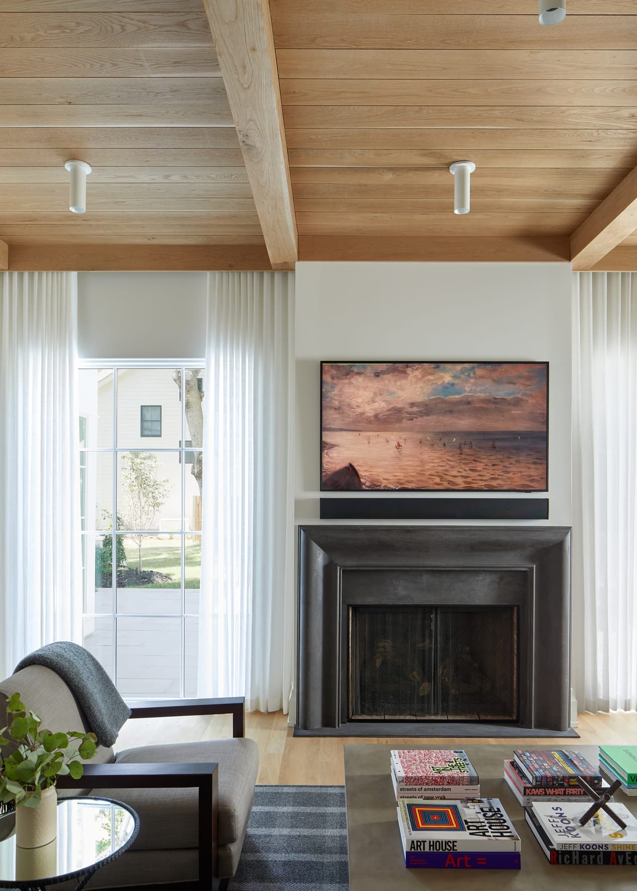 Cedar-planked ceiling on a painted beam over the fireplace end of a Westfield, NJ family room renovation, with a television above the mantel