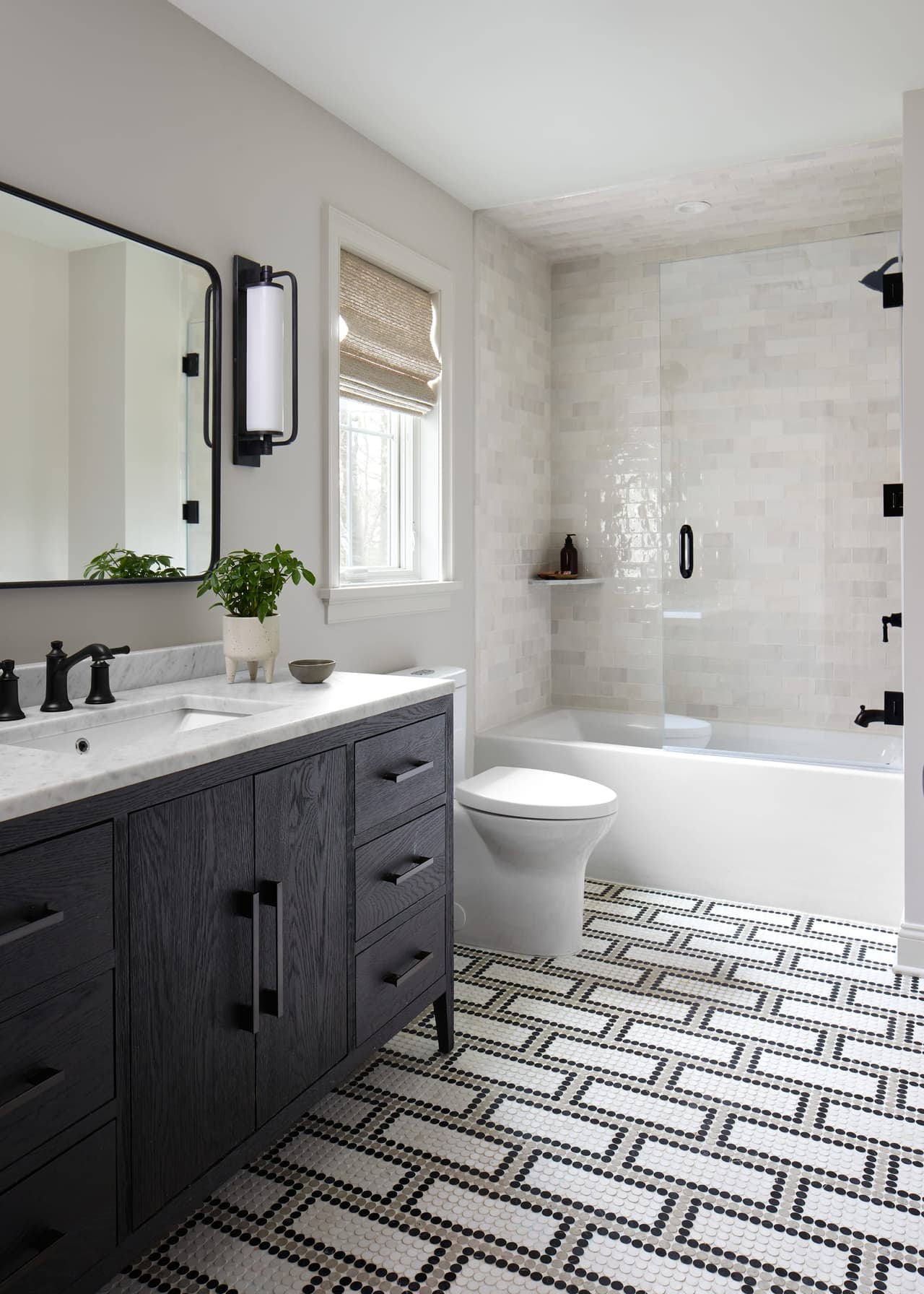 Bathroom in a Westfield, NJ renovation, with a charcoal double vanity, zellige-tiled walls and a patterned penny-tile floor