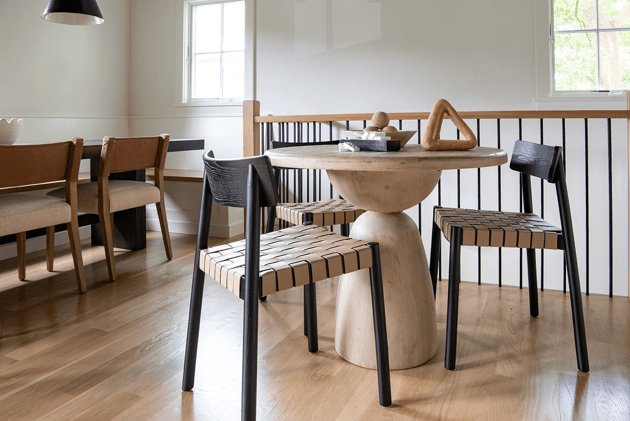 Game table on a sculptural pedestal base with woven black chairs, in a Westfield, NJ barn renovation