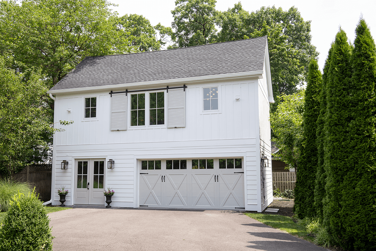 Two-story barn garage with white carriage doors and a gabled upper story at a Westfield, NJ barn renovation by Michael Robert Construction