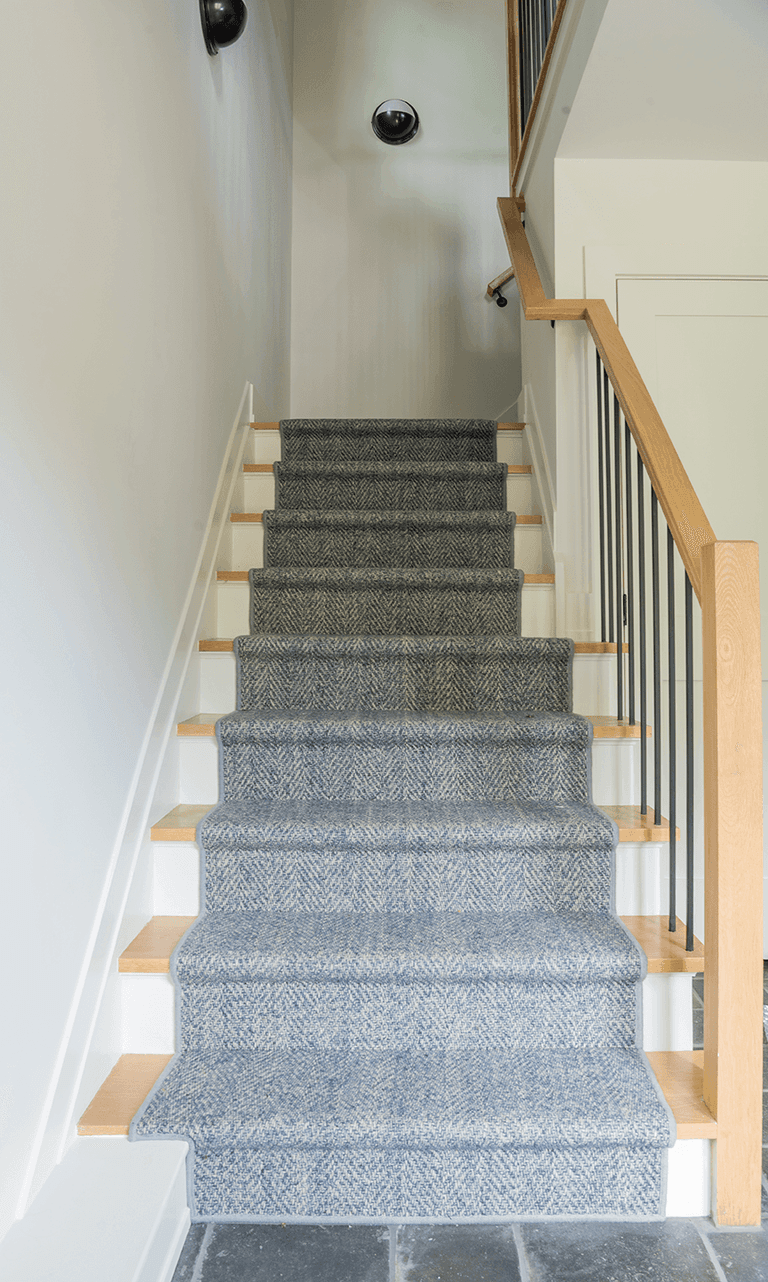 Stair of a Westfield, NJ barn renovation, with oak handrails, white balusters and a carpet runner up the treads