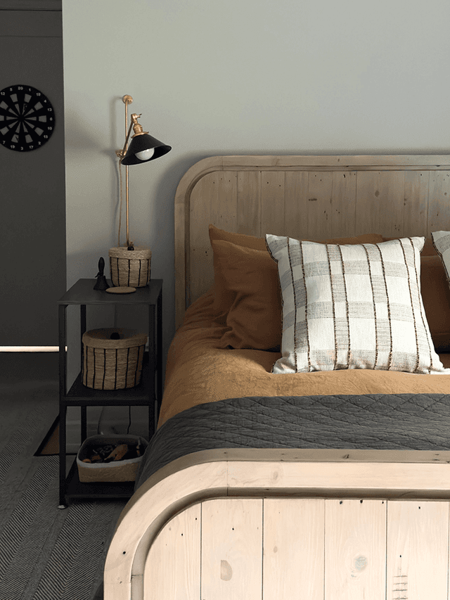 Child's bedroom in a Mendham, NJ home with a planked pine bed, a dark green wall and a black task lamp on an iron nightstand
