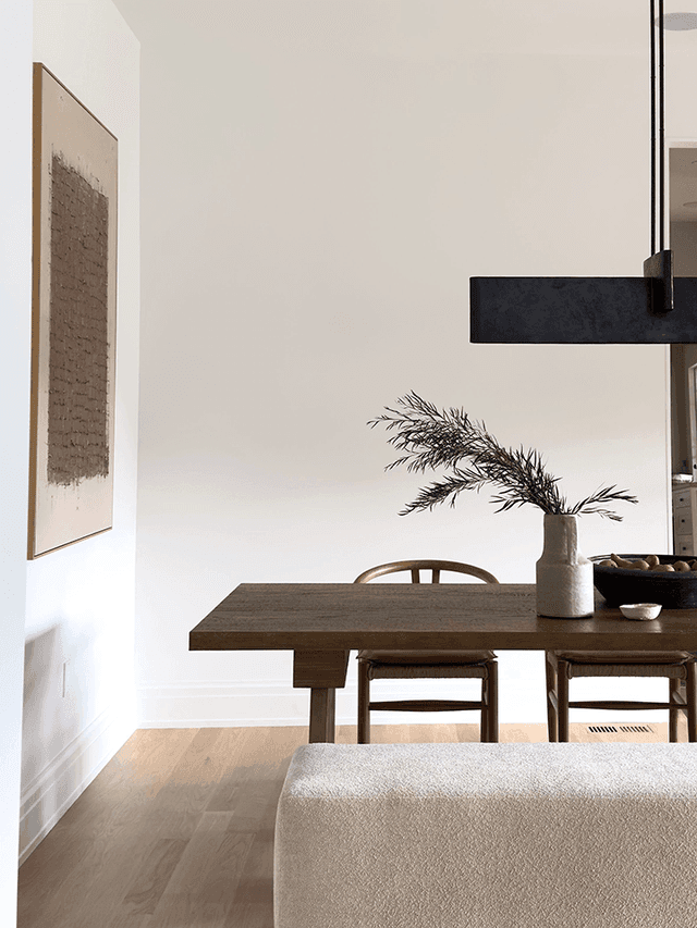 Dining room of a Mendham, NJ home with a dark wood table, spindle chairs, an upholstered bench and a linear black pendant above