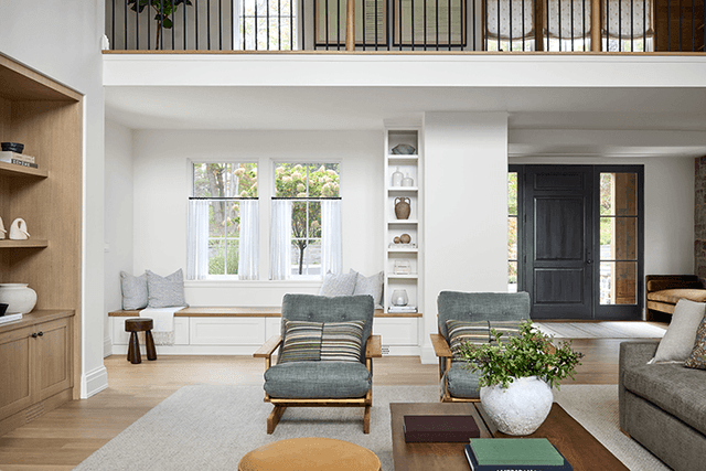 Custom built-in bench and upholstered chairs in the family room of a Mendham, NJ home, looking through to the hall and the black front door