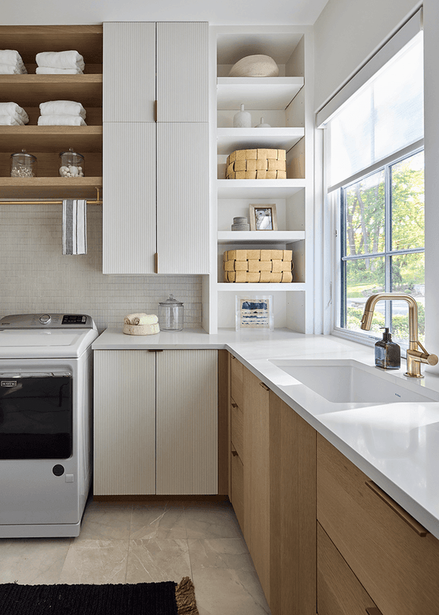 Second laundry in a Mendham, NJ home, with white fluted cabinet doors, open shelves, an oak base run and a brass tap over the sink