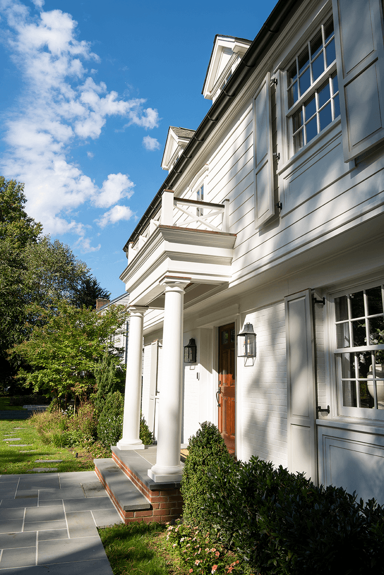 Side view along the portico of a Summit, NJ exterior renovation, showing the columns, the bluestone landing and the balustrade above