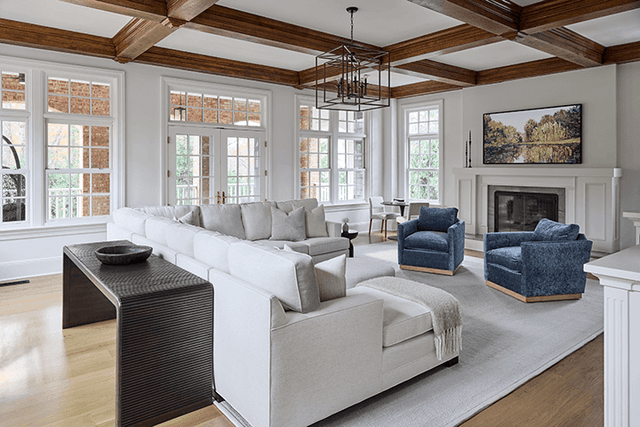 Stained beams and coffers across the ceiling of a Summit, NJ living room renovation, with windows on two sides and a fireplace at the end