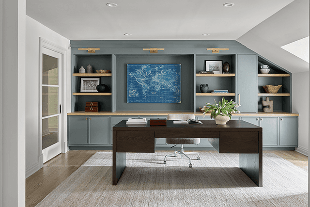 Office in a Summit, NJ renovation with pale blue built-ins around a framed map and a dark wood desk in the middle of the room