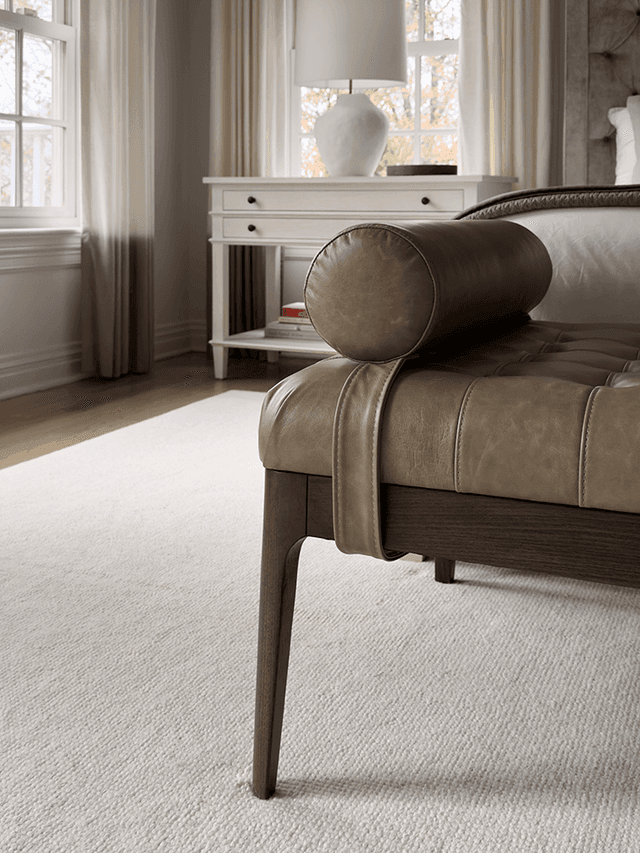 Leather bolster bench at the foot of the bed in a Summit, NJ primary bedroom, beside a painted console under the window