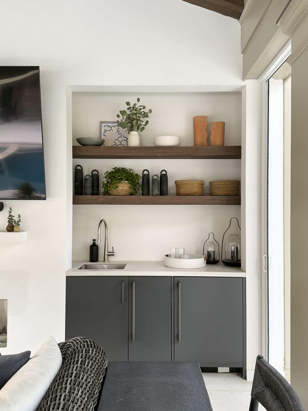 Kitchenette in a Westfield, NJ pool cabana, with charcoal cabinetry, oak shelves and a sink set into the counter beside the opening