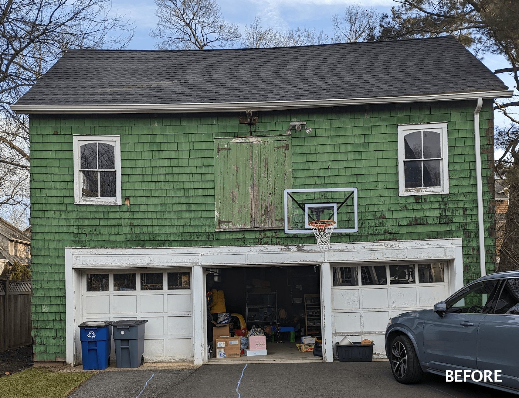 The backyard barn before renovation: green shingles, a basketball hoop and two garage doors, in Westfield, NJ