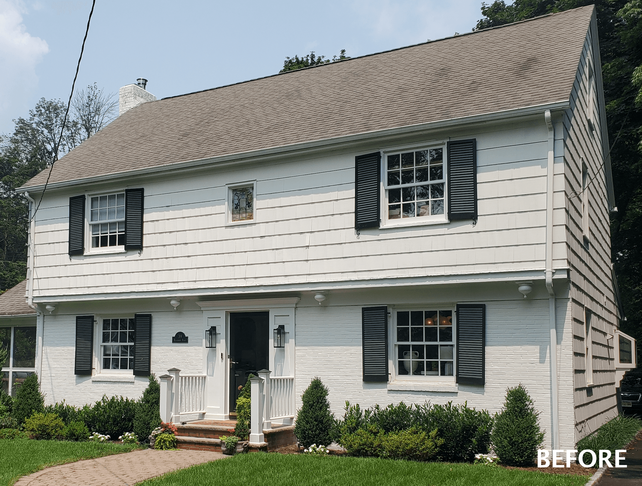 The home before its new design and construction: a pale clapboard colonial with dark shutters, in Summit, NJ